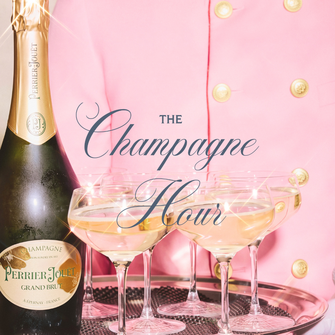 A champagne bottle and coupe glasses sit on a tray against a pink, gold-buttoned backdrop with decorative text.