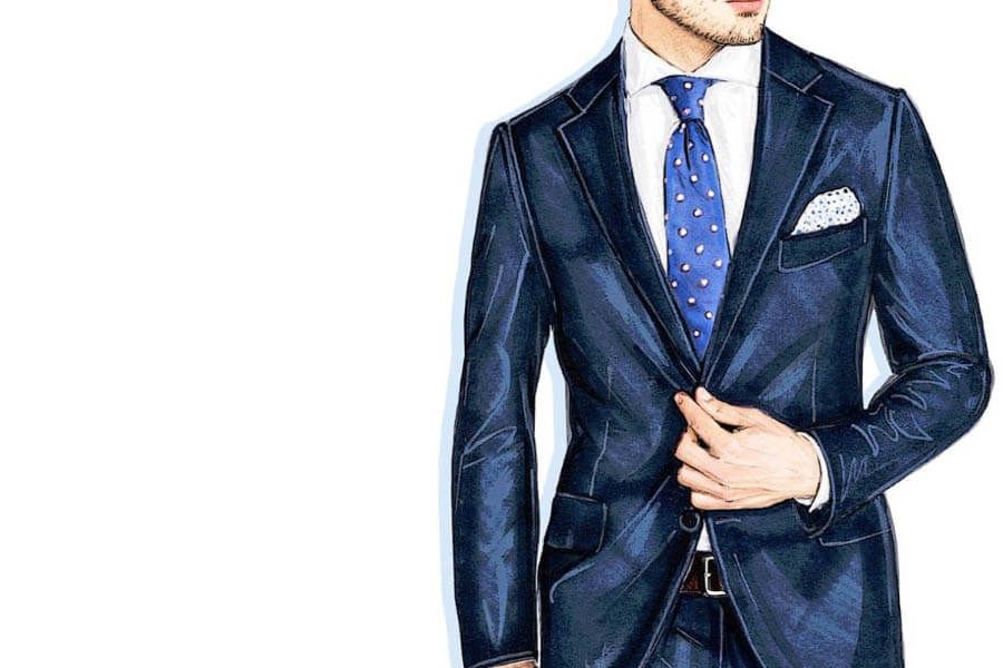 A man dressed in a tailored navy suit with a white shirt and blue polka dot tie, holding the suit jacket.