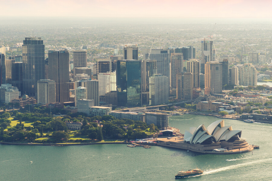 Sydney's skyline featuring the iconic Opera House and surrounding urban landscape with harbor and greenery.